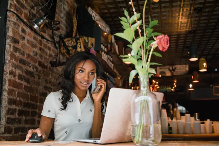 Businesswoman working on a laptop in a cosy cafe, representing a small business owner