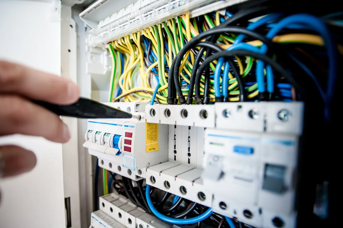 Electrician fixing an opened switchboard, representative of EICR preparation and checklist steps