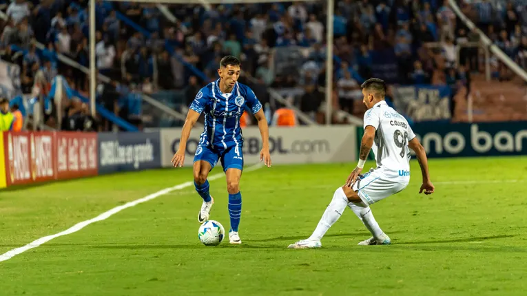 Intense football match action with two players competing for the ball on the field