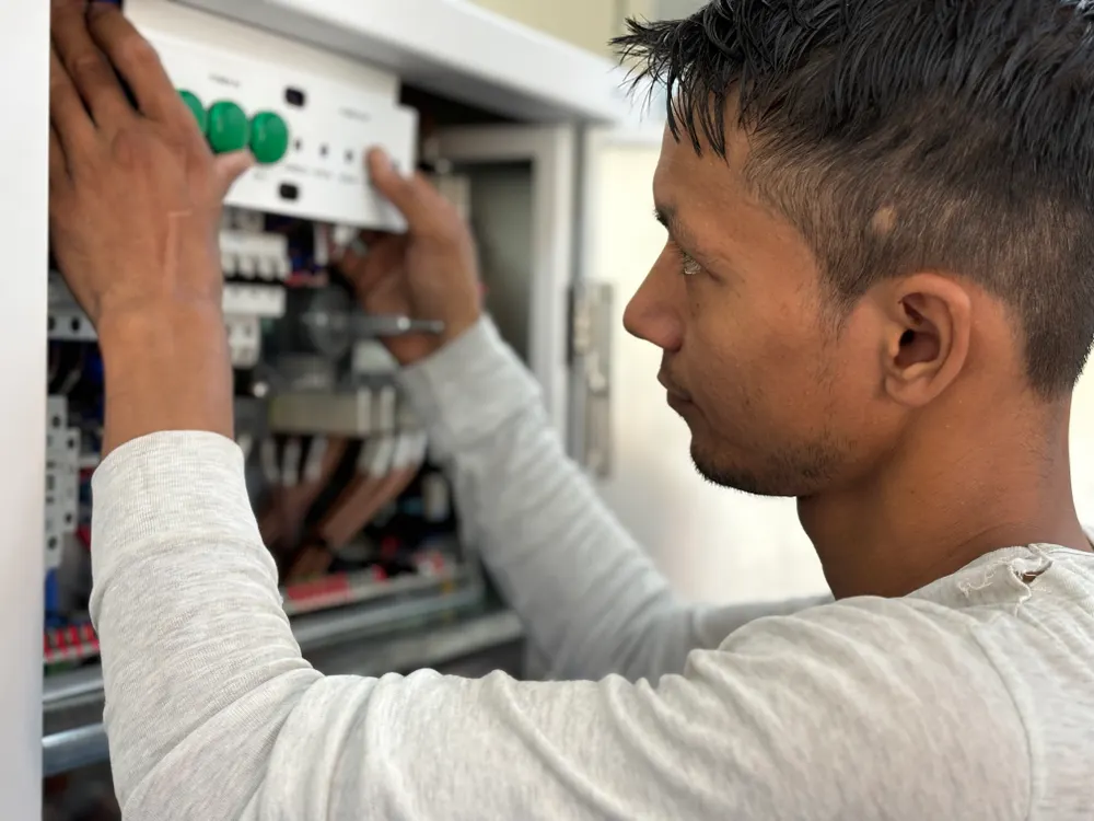 Electrician adjusting a circuit breaker panel during an electrical inspection